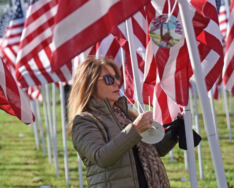 Mary Jo Porreca, Rotary Club board member and communications director, adds a medallion to a flag.