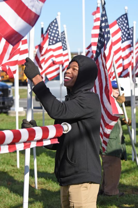 Darryl Sykes, a member of the Cape Henlopen High School JROTC program, has a good time as he places flags.