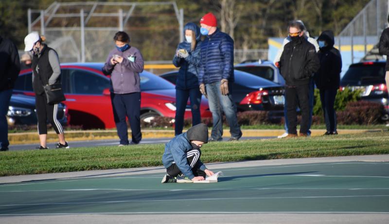 This young man sits on the Cape Henlopen High School basketball court as he waits for his parents to vote. RON MACARTHUR PHOTO