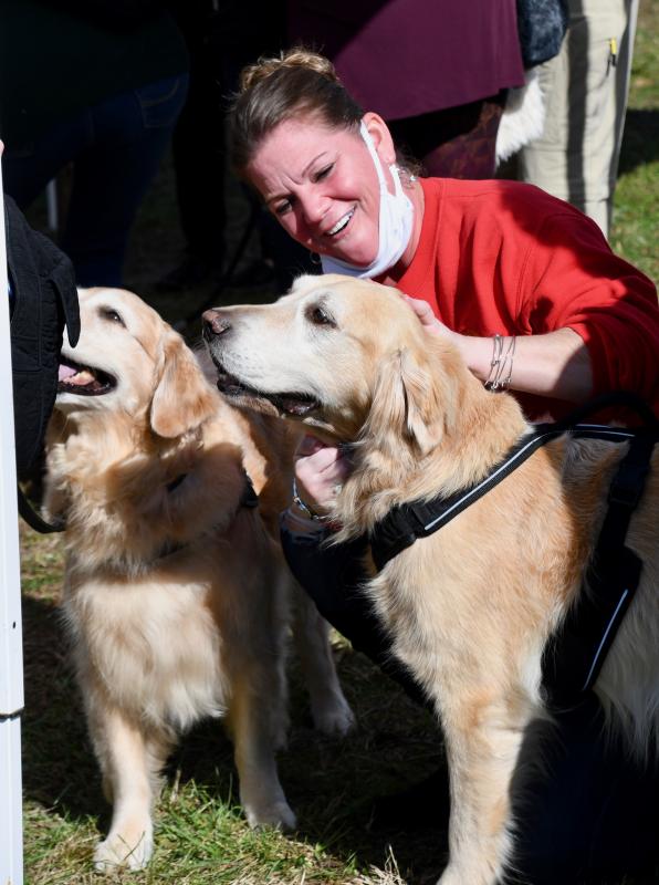 Candace Ruckle, a member of Indian River Volunteer Fire Department, gets up close and personal with two rescue dogs.