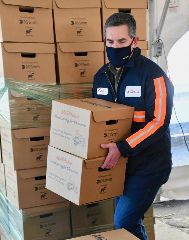 Mountaire Farms President Phillip Plylar gets involved in the project by stacking finished food boxes.