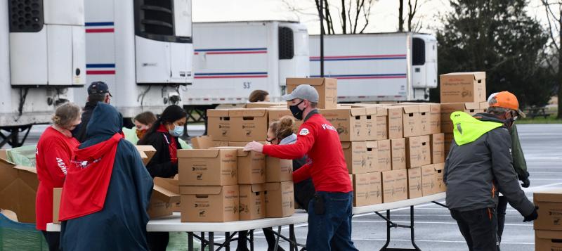 Thanksgiving for Thousands volunteers prepare food boxes to be loaded in waiting vehicles and trailers.