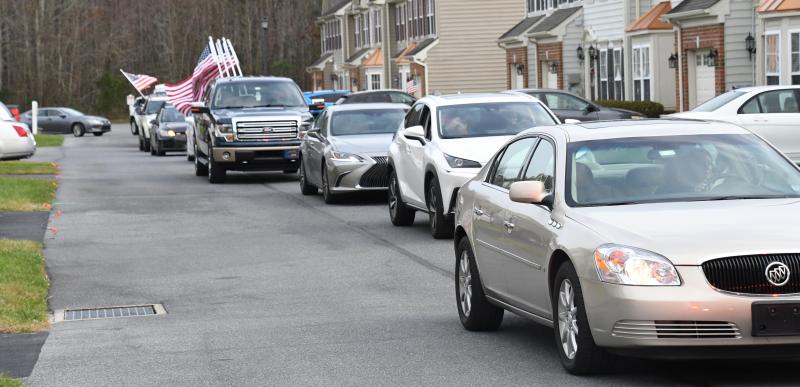 A long line of vehicles makes a turn onto the street where Tom Creekmore lives in the Bayshore community off Long Neck Road.
