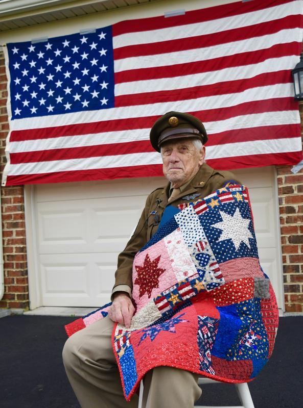 Veteran Tom Creekmore is wrapped in a Quilt of Valor presented to him by representatives of the foundation.