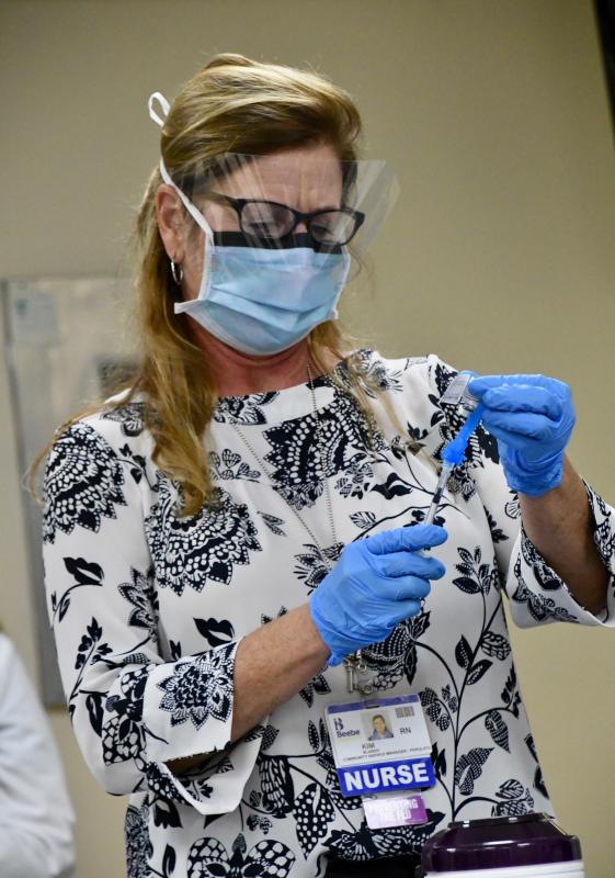 Beebe Healthcare nurse Kim Blanch draws a dose of the vaccine from a vial that holds five doses, the first five administered in Sussex County.