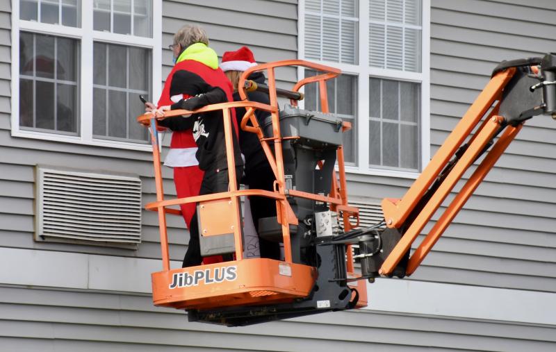 Leighton family members – grandson T.J., son Richard, and daughter-in-law Suzy – go up to the second-floor window to visit with Tom Leighton, a resident of The Moorings at Lewes. RON MACARTHUR PHOTOS