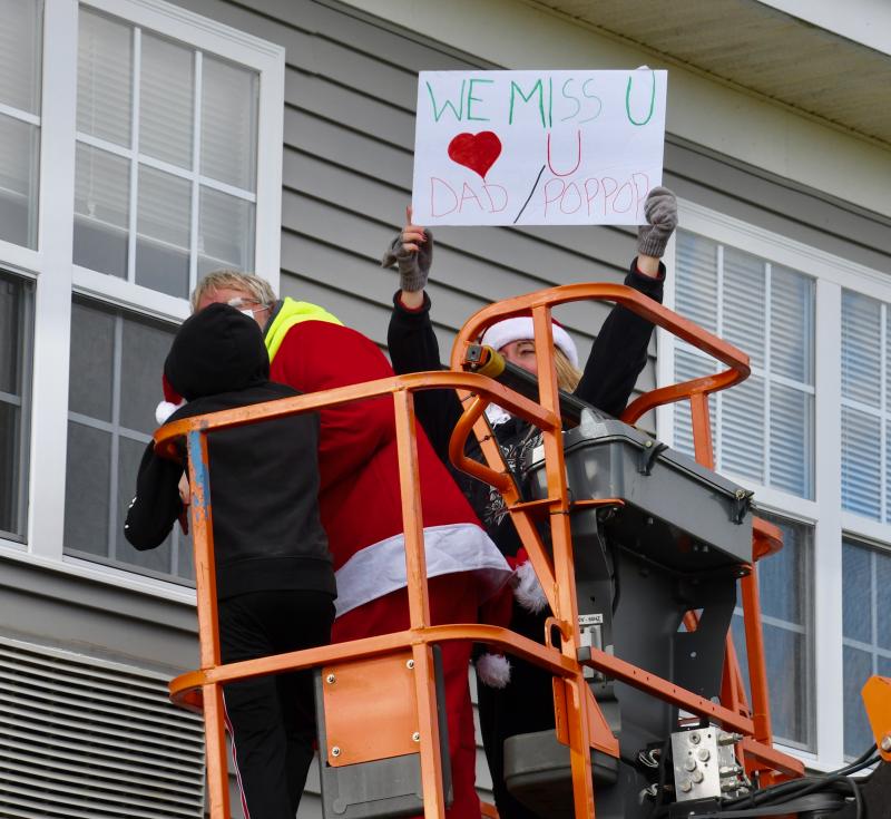 Suzy DuBois-Leighton holds up a sign she made for her father-in-law.