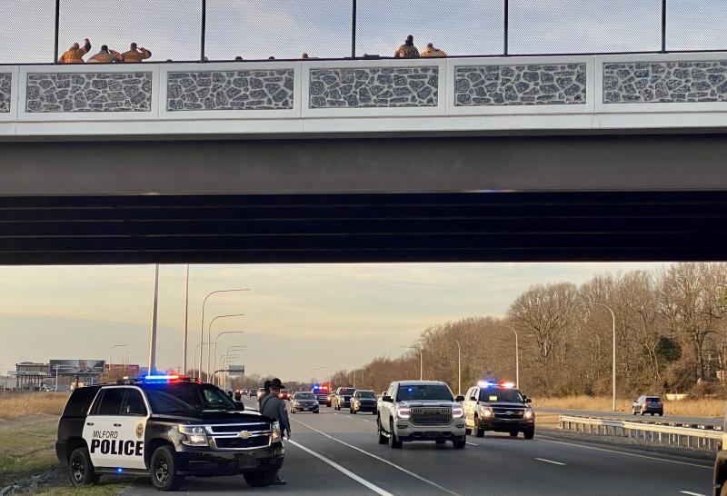 Officers from the Milford Police Department and, on the overpass, members of local fire departments and emergency personnel, cheer as an entourage escorts Sr. Cpl. T.J. Webb home from a rehabilitation center, where he has been recovering from gunshot wounds sustained Dec. 10 near Rehoboth Beach. JEN ELLINGSWORTH PHOTO