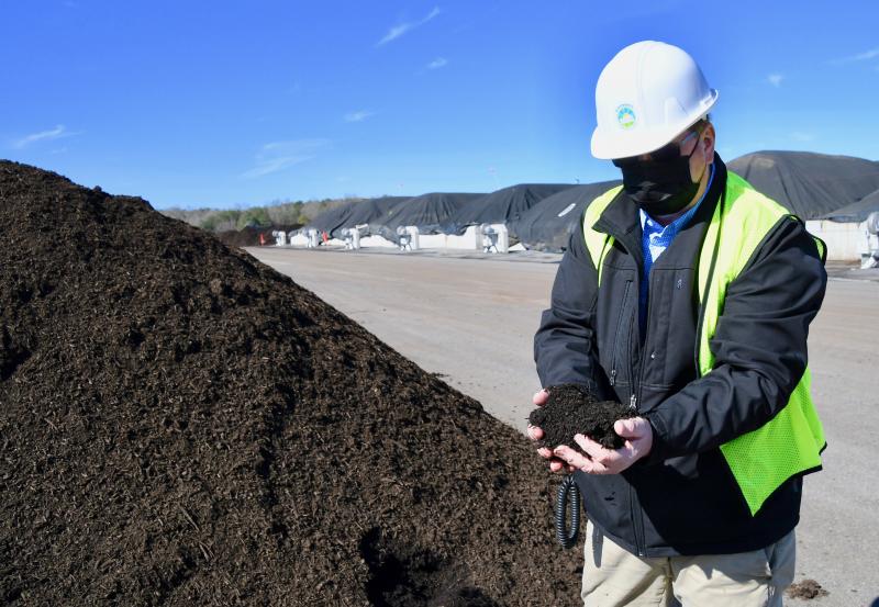 Plant manager Jeff Deats shows what the end composting product looks like. It takes four to five months before the mix of wood chips and poultry waste reaches this point.