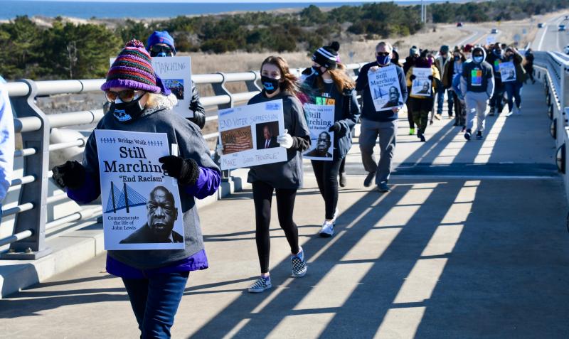 Walkers hold up “Still Marching” signs referring to the famous walk across the Edmund Pettus Bridge by civil rights leaders on March 7, 1965, in Selma, Ala.