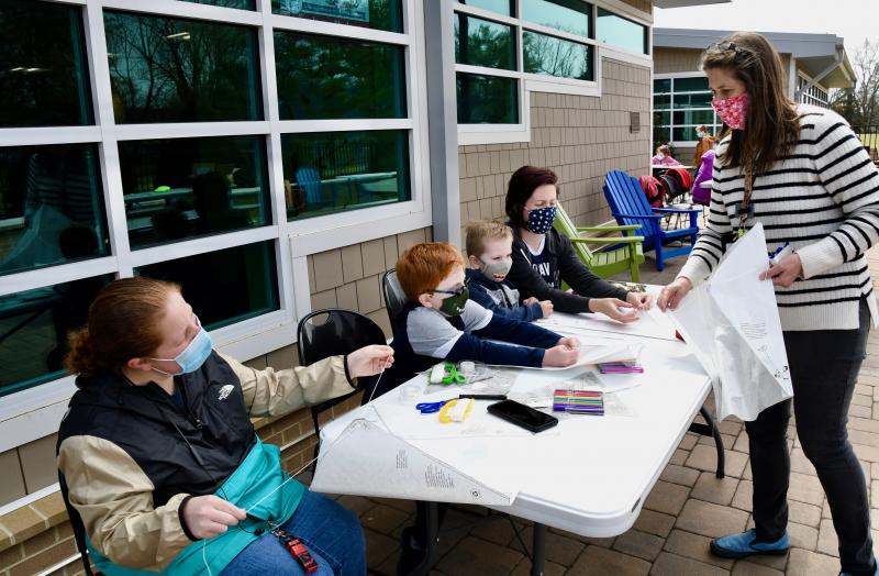 Lewes children’s librarian Jen Noonan helps (l-r) Raven Ferrell and Jackson, Harrison and Brooke Smith finish up their kites.