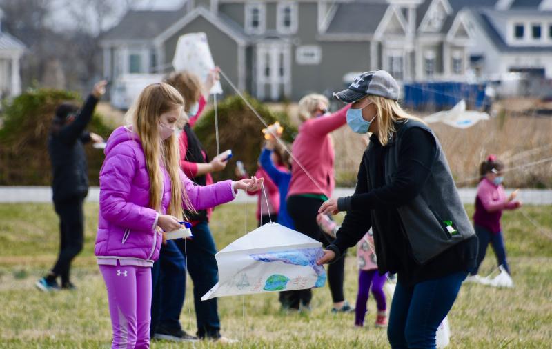 Carissa Balliet, left, gets some help from Rachel Webster of Rehoboth Toy & Kite as kite flyers take to the field adjacent to Lewes library.