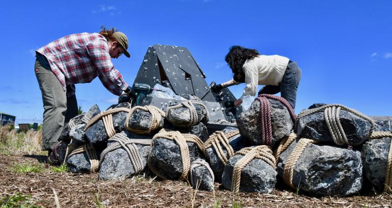 Emmett Ryan, left, and Rachel Mica Weiss work together assembling and attaching the rocks of “Unbounded II” as they get started April 17. RON MACARTHUR PHOTO