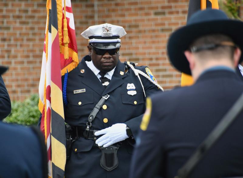 A member of one of dozens of police honor guard units bows his head in memory of the fallen Delmar officer.