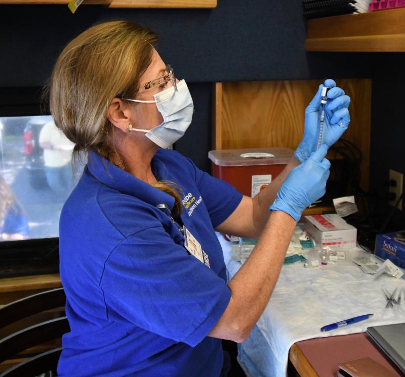 Kim Blanch, Beebe Population Health services manager, prepares needles with Pfizer vaccine at the start of a May 13 mobile clinic in Milton.