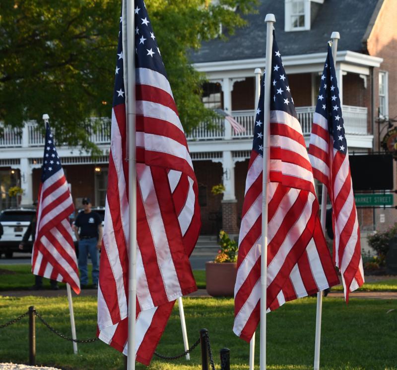 Rays from the setting sun highlight the colors of United States flags flying on The Circle during a rally of support for law enforcement.