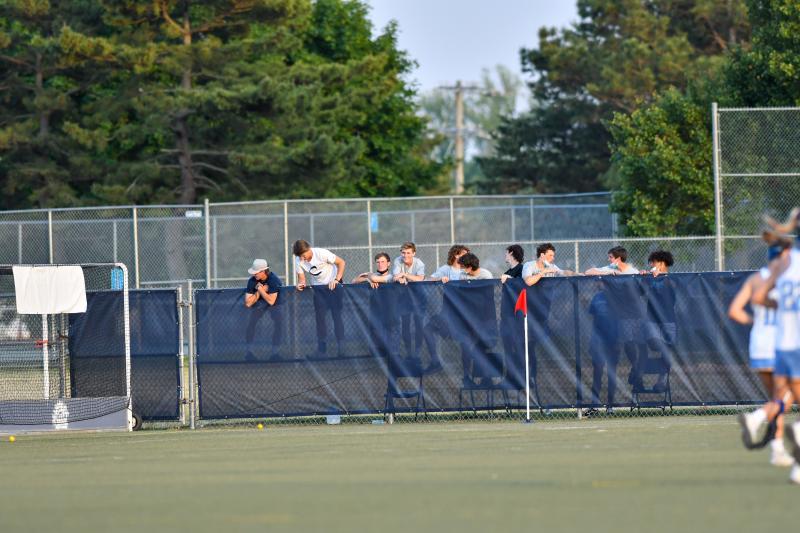 The boys’ lacrosse team can’t see over the new wind screen but made adjustments.