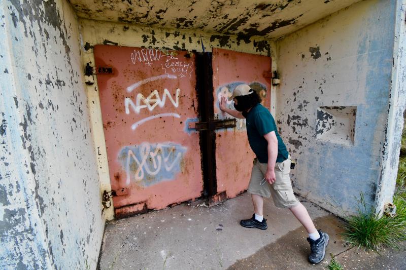 Tyler Dreiblatt, Cape Henlopen State Park interpretive program manager, closes the massive steel doors which provide access to Battery Herring.