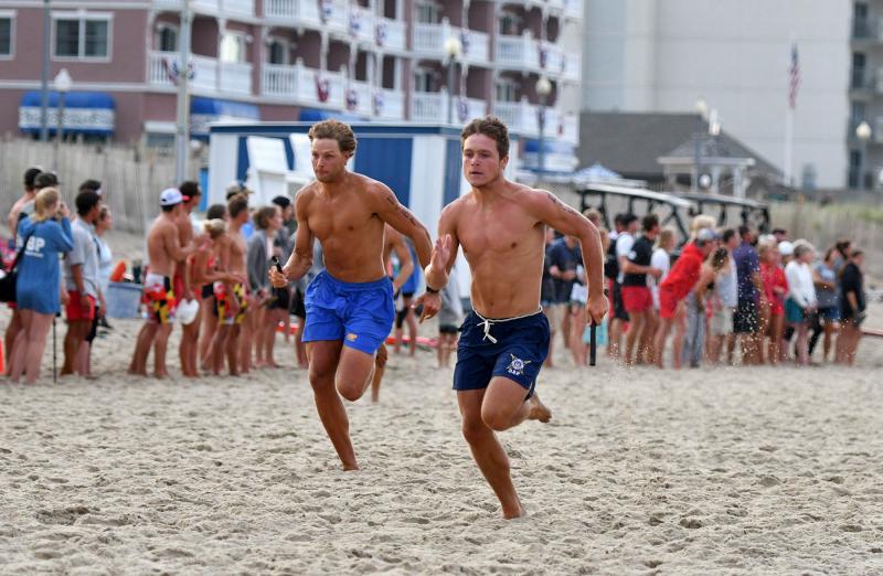 Dewey Beach Patrol rookie Mikey Frederick, right, squeezes out the lead from Delaware State Parks’ Anthony Hitchcock as they sprint to their teammates in the 4-by-200 soft sand relay.
