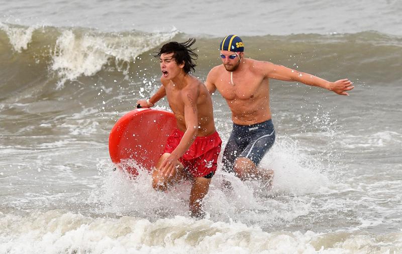 Rehoboth Beach Patrol’s Rawley Florax, left, and Xander Geiersbach exit the ocean in the paddleboard rescue race. DAN COOK PHOTOS