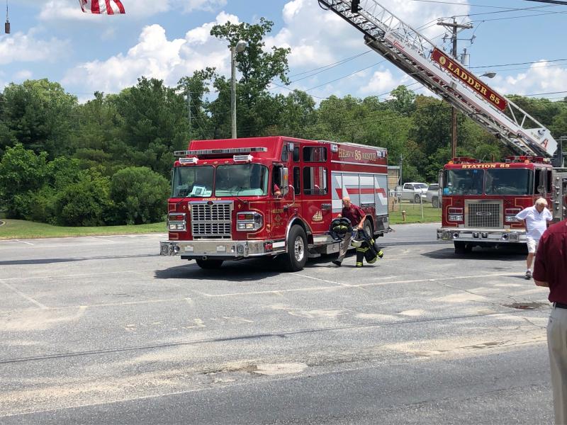 During the July 17 event, the fire alarm rang out, causing firefighters in their polo shirts and khakis to have to head out on the call. Chief Johnny Hopkins loads his gear into the fire engine to respond.