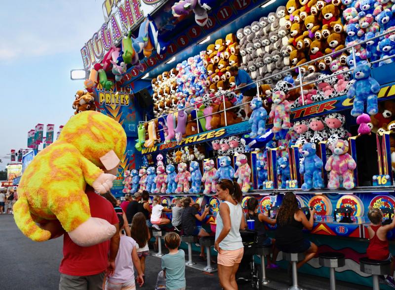 This photo proves that some fair-goers win those giant stuffed animals. More stuffed bears are up for grabs at the one of the largest games on the Midway.