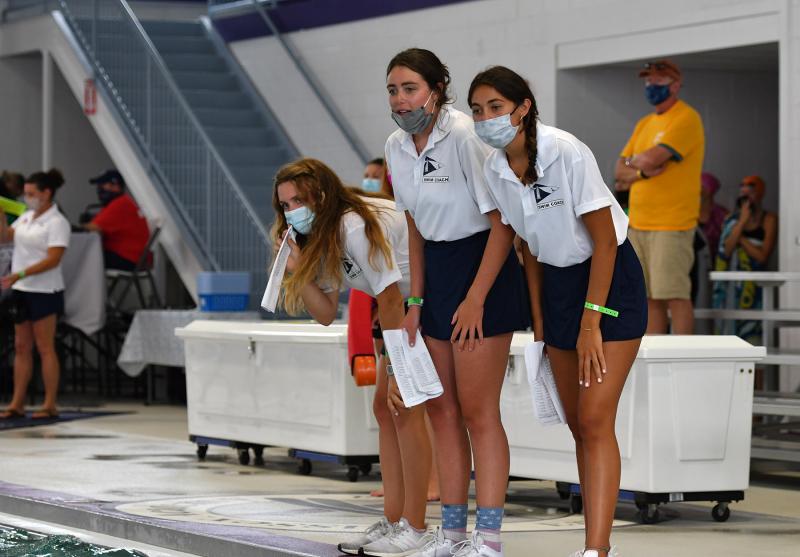 Lewes Yacht Club coaches cheer on their medley relay team. Shown are (l-r) Julia Martiner, Fiona Pando and Tess Mariner.
