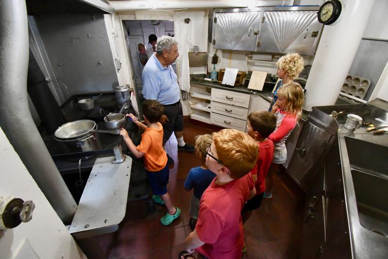 Children taking a tour of the Overfalls crowd into the galley to learn about life on the ship from volunteer tour guide Steve Tolbert.