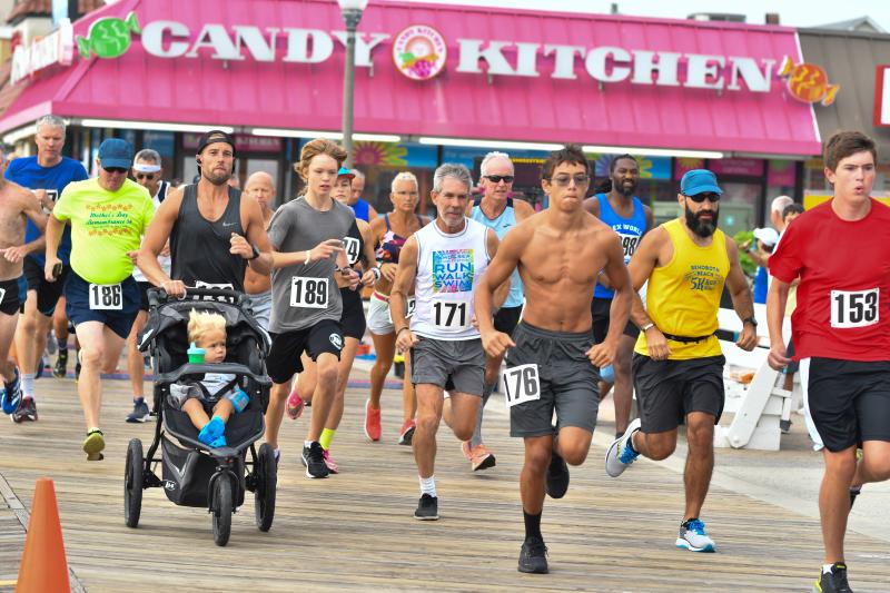 Runners spring from the iconic Candy Kitchen store at the start of the Sun Festival 5K. DAVE FREDERICK PHOTOS