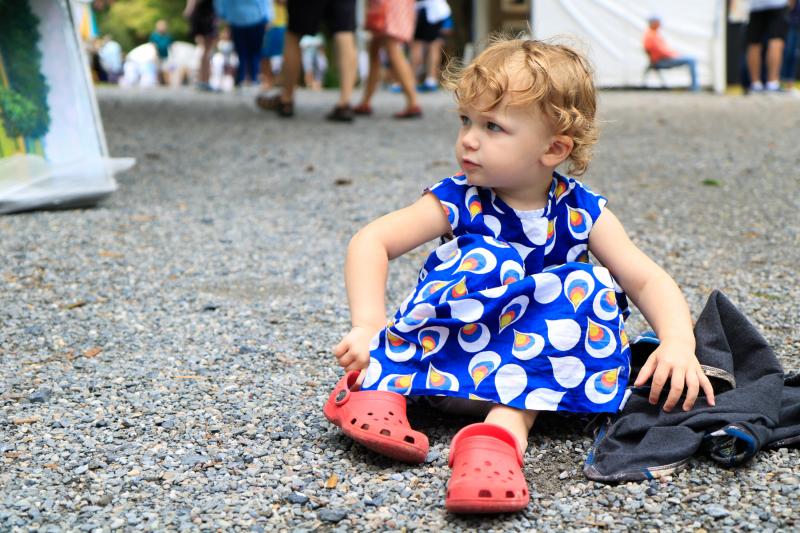 Rory Lustberg, 2, of upstate New York, smiles at her mother as she puts her shoes back on during the RAL’s outdoor show Sunday.