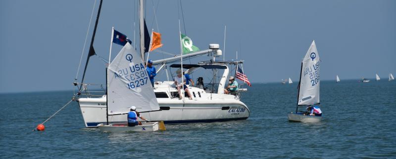 Sofia Cole (16237), Severn Sailing Association, crosses the finish line during Optimist green competition. She finished third in the fleet.