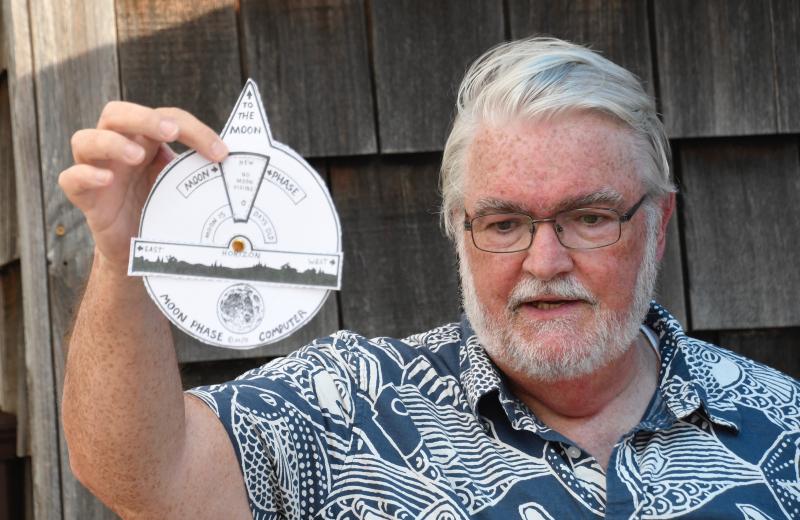 Jim O’Leary, a retired astronomer and volunteer, shows children making a moon phase dial what it should look like.