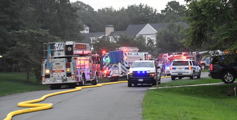 Fire trucks and other vehicles line Peregrine Road after responding to a fire in the Hawkseye community.