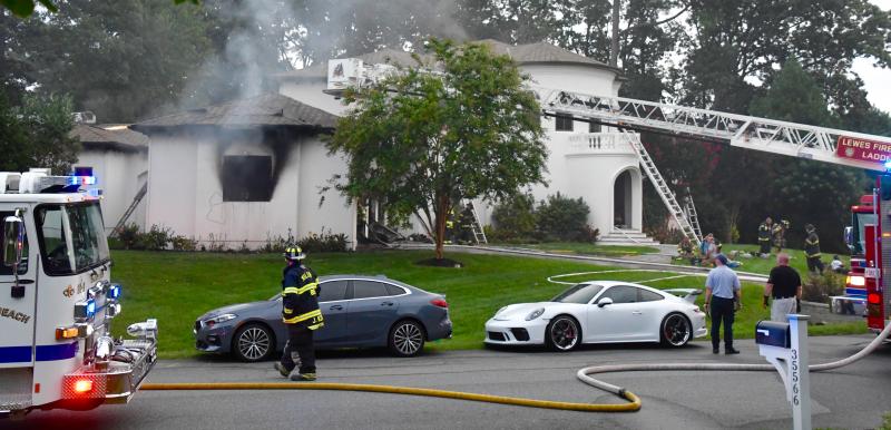 Smoke pours from the garage of a house as dozens of firefighters respond to the fire in the Hawkseye community.