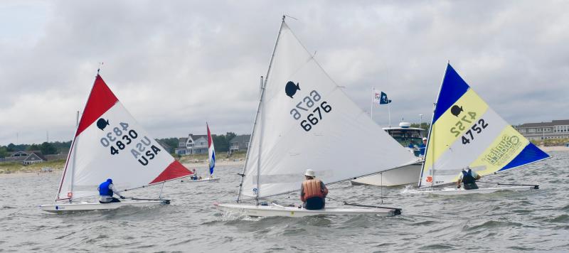 The top three finishers in the Sunfish Regional Championship head to the finish line in one of five races. They are (l-r) Nancy Jaywork (4830), first place; John Barrere (6676), third place; and Jim Knab (4752), second place. All are members of Rehoboth Bay Sailing Association.