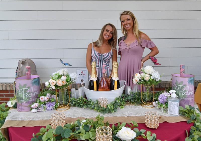 Brittany Sapp, left, and Shannon O’Brien work the Breakthru Beverage booth which included the Palm by Whispering Angel.