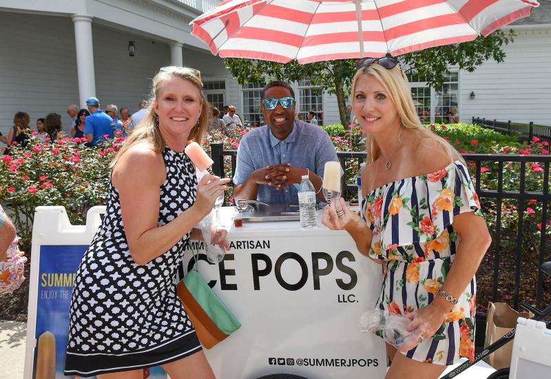 Enjoying a tasty summer treat from Summer J Pops owner Queon Jackson, center, are Jen Clem, left, and Amy Antos.