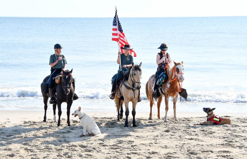 Videographer Jacqueline Taylor on Phin, Lisanne Fear on Chileno and Hannah Catlino on Rosette stand at attention for the national anthem before the departure ceremony.