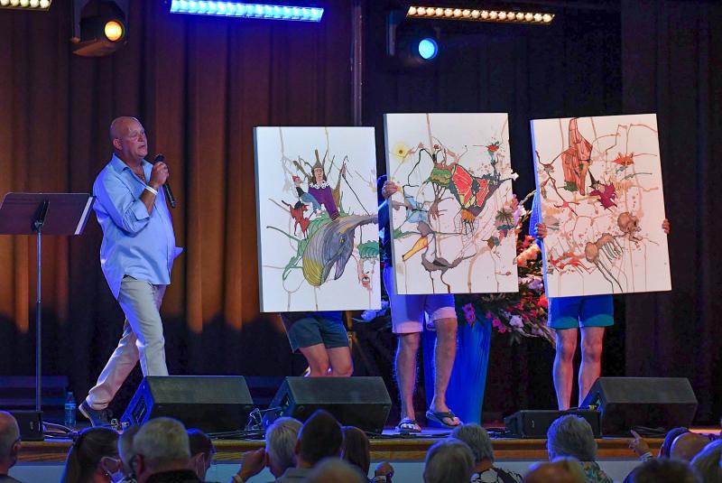 The Sun Festival live auction took place Friday and Saturday night, when funds were raised through donations of art, jewelry and vacation getaways. Auctioneer Lorne Crawford gets bids for a three-panel painting by local artist Kim Klabe. Titled ”King of Pain,” based on the song by rock group The Police, it has over 40 images referencing the lyrics. DAN COOK PHOTOS