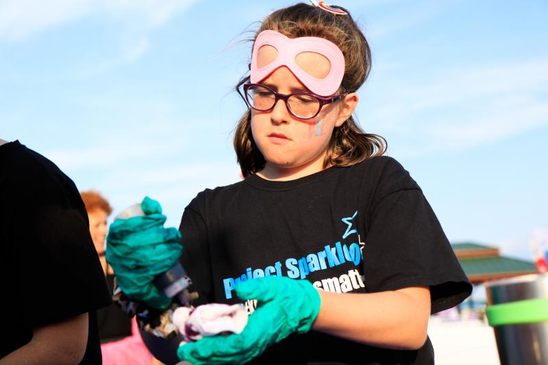 Evelyn McDorman, 9, who helped raise funds for Relay for Life, works diligently making a tie-dye sock at the event.