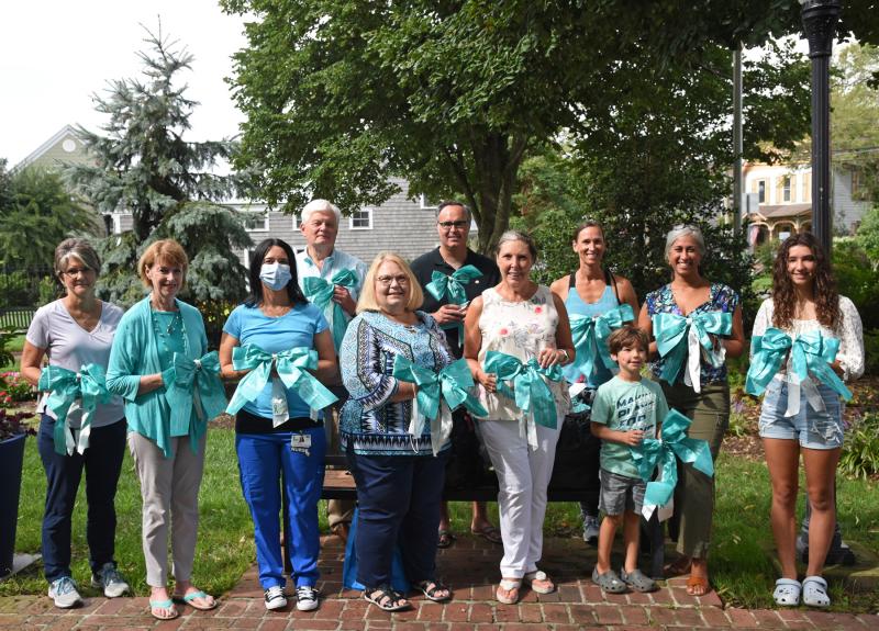 Participating in the annual Turn the Town Teal event in Lewes are (l-r) Janet Reeves, Lewes parks and marina administrator; Betsy Reamer, executive director of Lewes Chamber of Commerce; Monica Scott of Beebe community outreach; Mayor Ted Becker; Debbie Campbell, Beebe cancer screening nurse navigator; Sen. Ernie Lopez, R-Lewes; Henrietta Belcher-Stack, event organizer; Kelly Serpico; Brooks Serpico; Rita Williams, Beebe manager of oncology psychosocial services; and Sienna Serpico. NICK ROTH PHOTOS