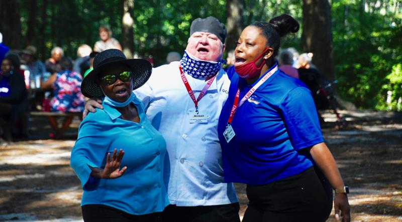 Singing and dancing are (l-r) Mildred Riley of Greenwood, CHEER cook Steve Carroll and Roxana CHEER Center Director Sharice Franklin.