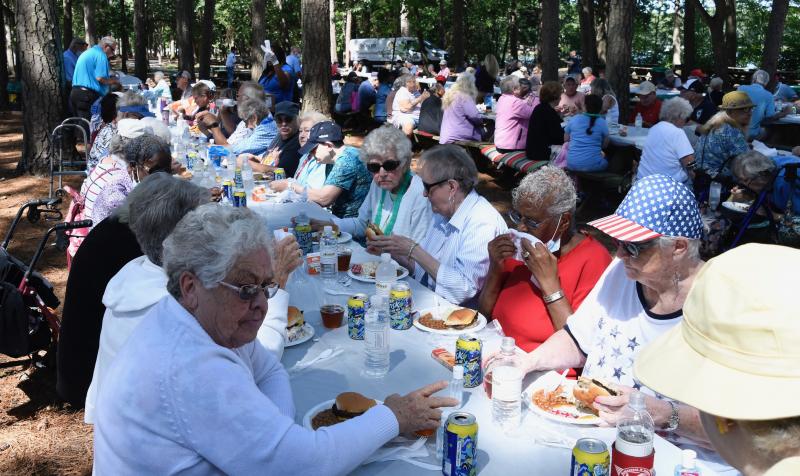 A large crowd of seniors from throughout Sussex County sits down to lunch during the CHEER picnic at Trap Pond State Park near Laurel.