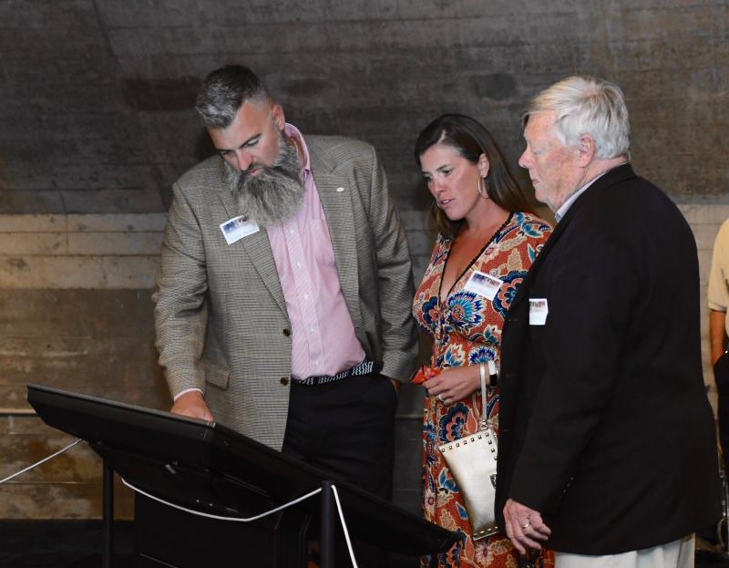 Premier sponsor of the exhibit is The Christian and Julie Hudson Family Foundation. At the opening, Christian, far left, and Julie learn about the exhibit from Horizon Philanthropic Services principal Mike Rawl. Horizon raised funds for the exhibit.
