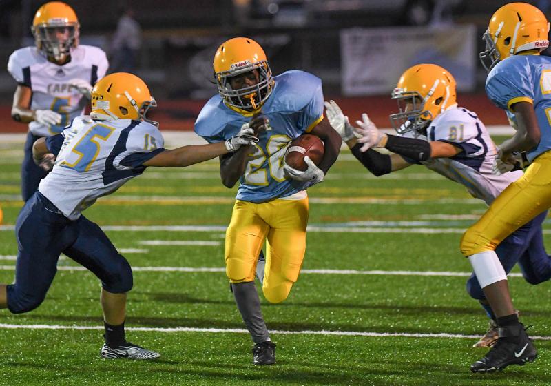 Mariner’s Cameron Greene, center, runs through the tackle attempts by Beacon’s Elijah Ghabour, left, and Mason Jack.