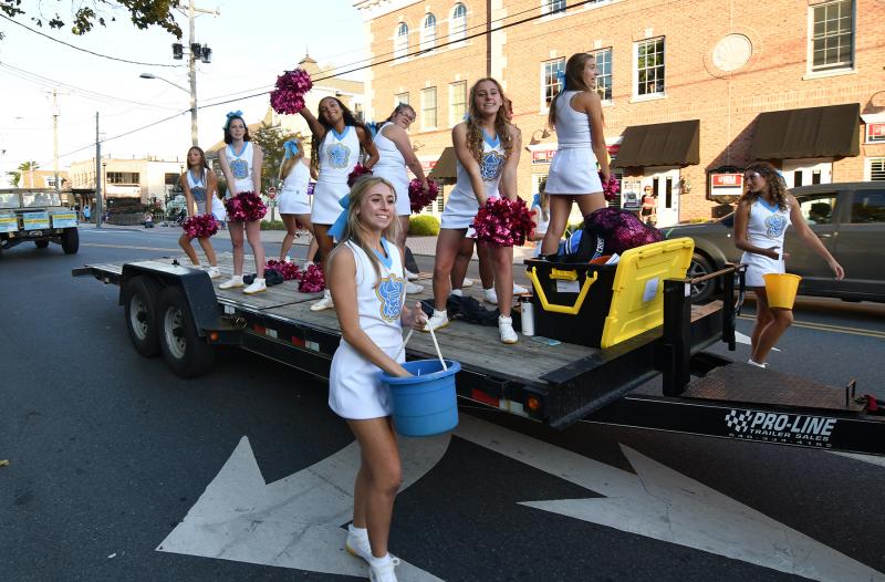 Cape sophomore cheerleader Emily Groll, center, hands out candy as she walks beside the Cape cheerleaders’ float.
