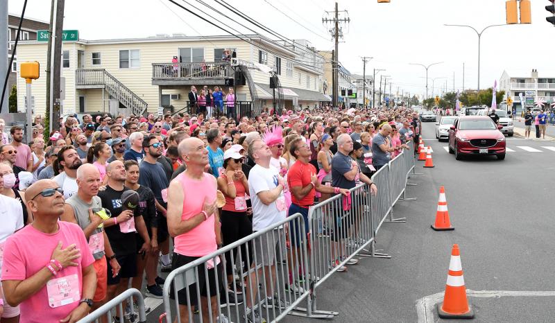 The crowd stands at attention while Kristen McGee of Kristen and the Noise sings the national anthem before the race.