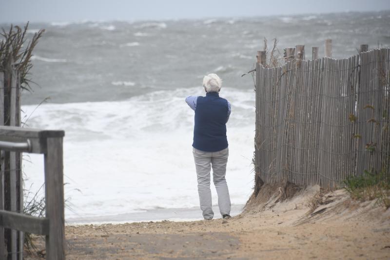 A Rehoboth Beach visitor braves the wind and blowing sand to take photos of an angry ocean. RON MACARTHUR PHOTO