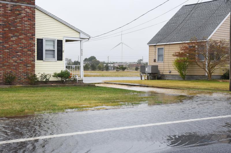 The UD wind turbine can be seen off in the distance as flooding creeps closer to these Cedar Street homes in Lewes. NICK ROTH PHOTO