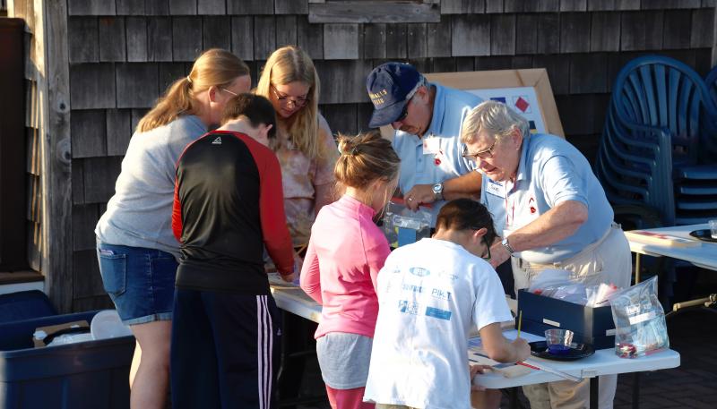 Lightship Overfalls volunteers Steve and Susan Tolbert help campers paint their own nautical flag artwork.